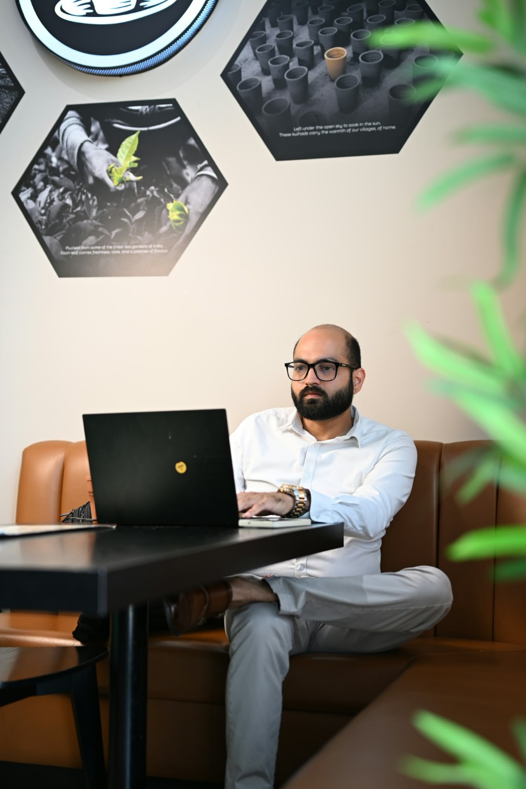 Shikhar Sood working on his laptop at a café